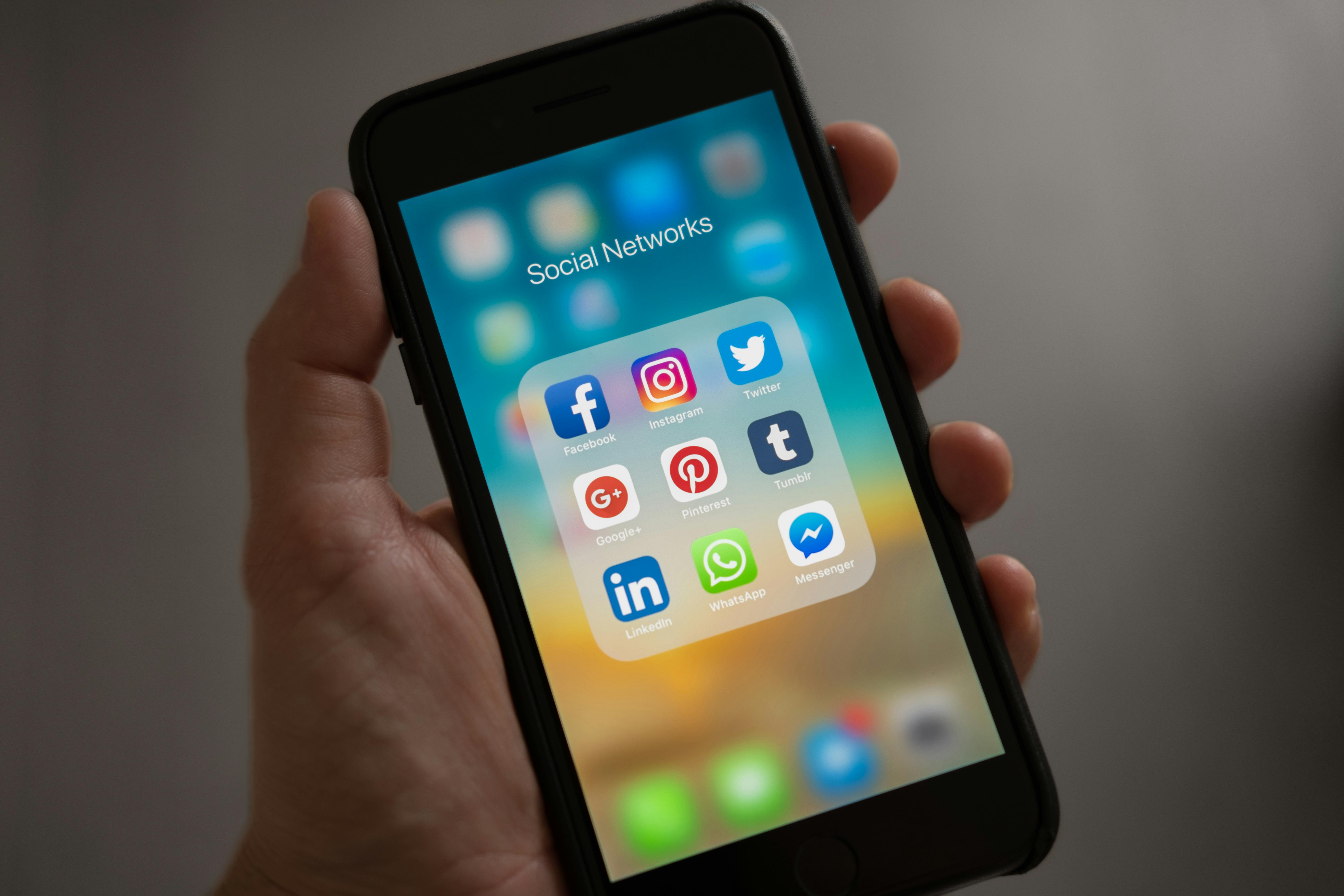 Foto de um celular com ícones de redes sociais na tela